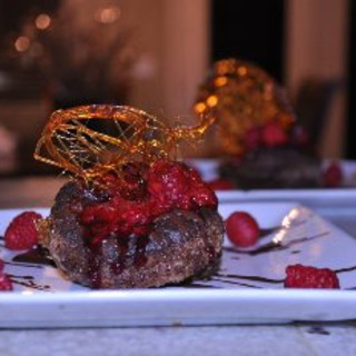 Collapsed Chocolate Souffle topped with raspberry sauce