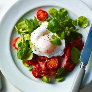 Fried bacon with poached egg and tomatoes