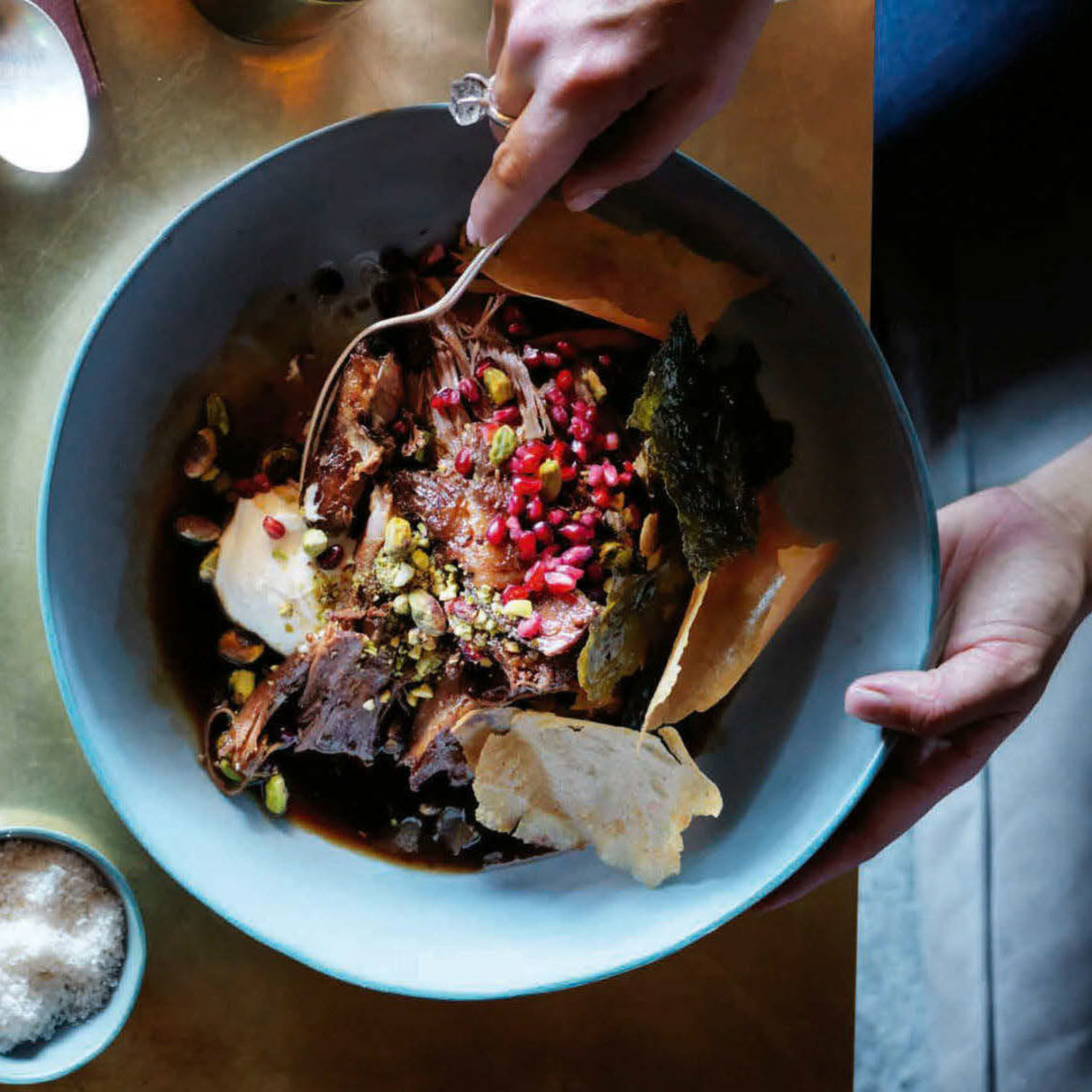 Slowroasted lamb shoulder with pistachios, pomegranate and vine leaves