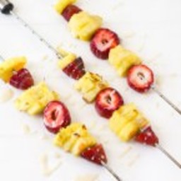 Grilled pineapple and strawberries skewers with bourbon white chocolate gla