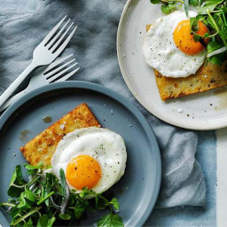 Hash browns with eggs fried in olive oil and herb salad