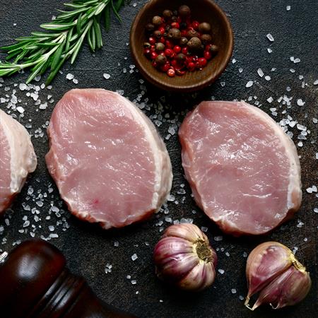 slices of raw pork meat with ingredient for making recipe on slate