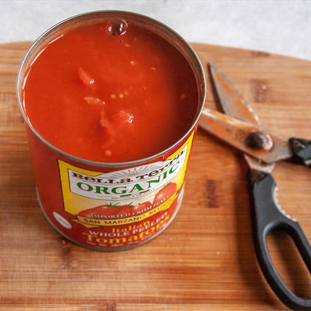 can of tomato sauce on cutting board from top down view