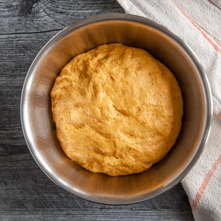 overview of batter for pumpkin cinnamon rolls in stainless steel bowl