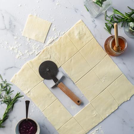 overhead of dough rolled out with filling in scooper 