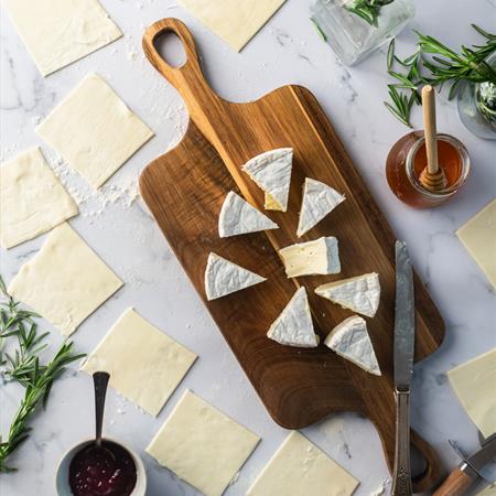 brie on cutting board with phyllo dough on countertop overview