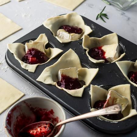 side view of filled cranberry brie bites in muffin tin