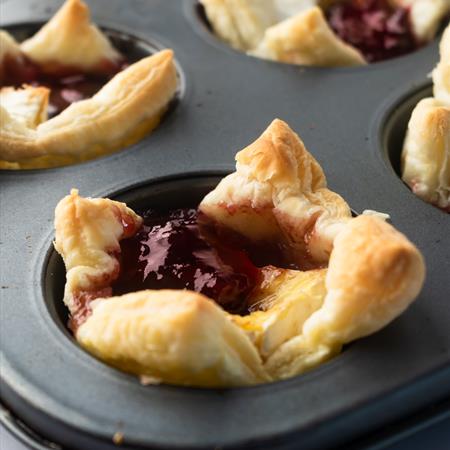 baked cranberry brie bites from the side on a white countertop