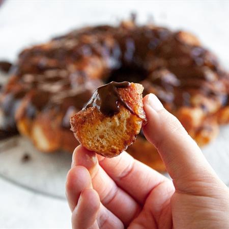 finished doughnut monkey bread with a bite in a hand