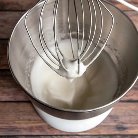 egg whites in stand mixer from side angle