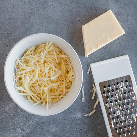 freshly grated cheese in a white bowl from overhead